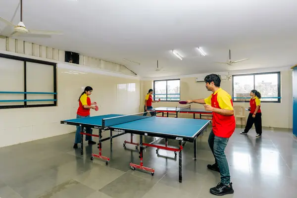 Four students playing table tennis at school