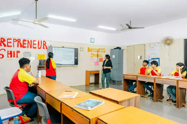 Teacher teaching students using a digital board in the classroom