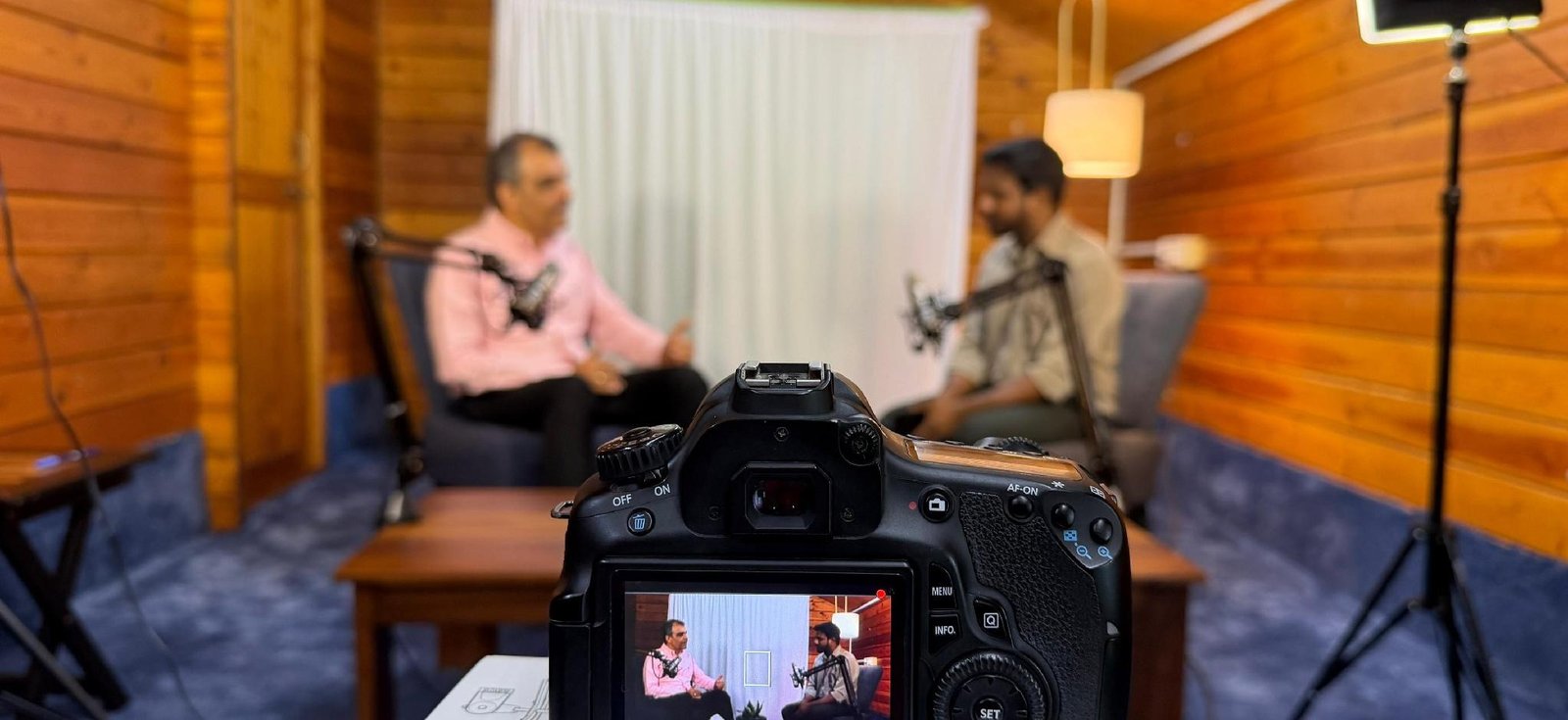 Two people are having a conversation on a podcast in a studio