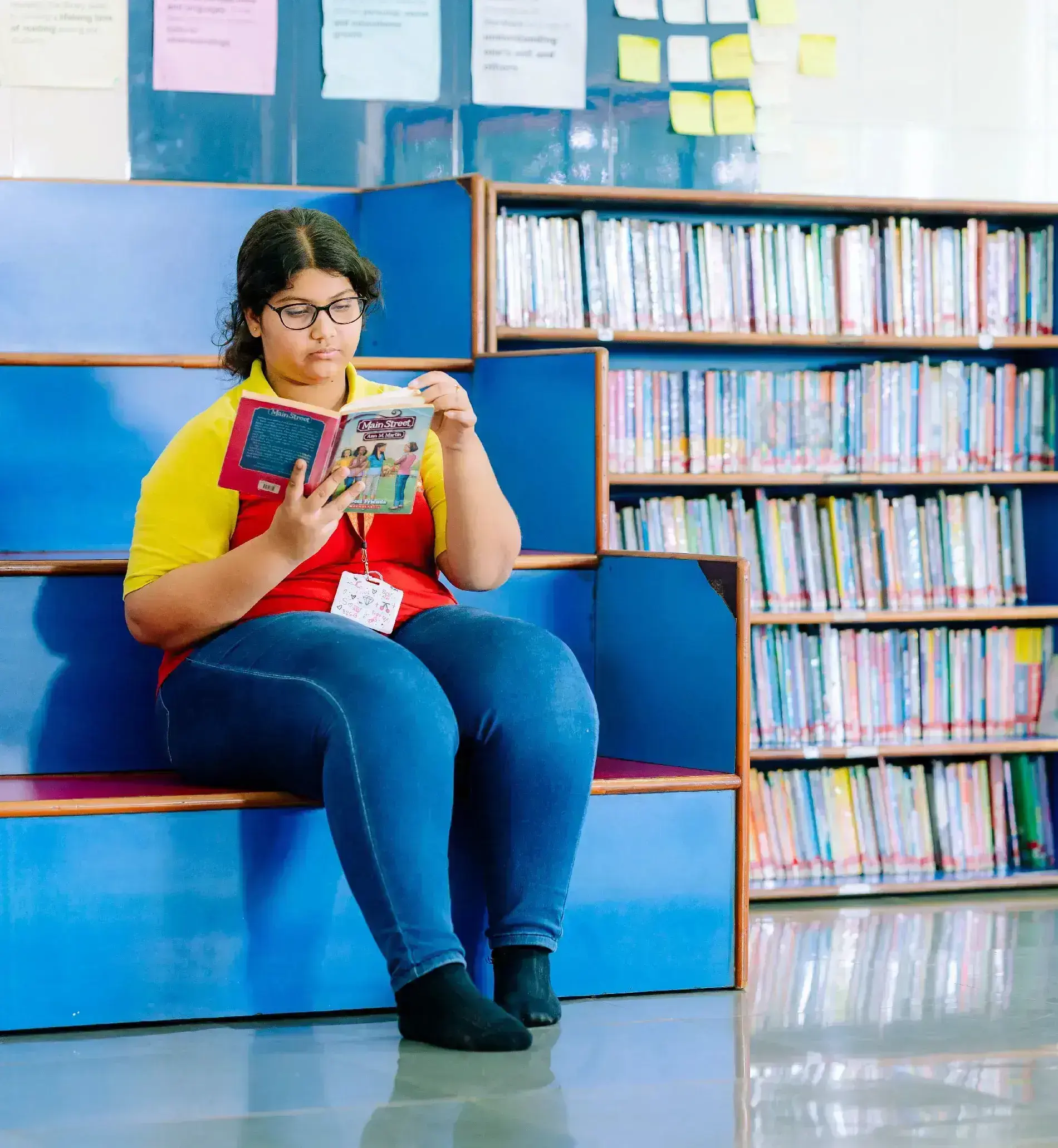 School student reading a book in the library