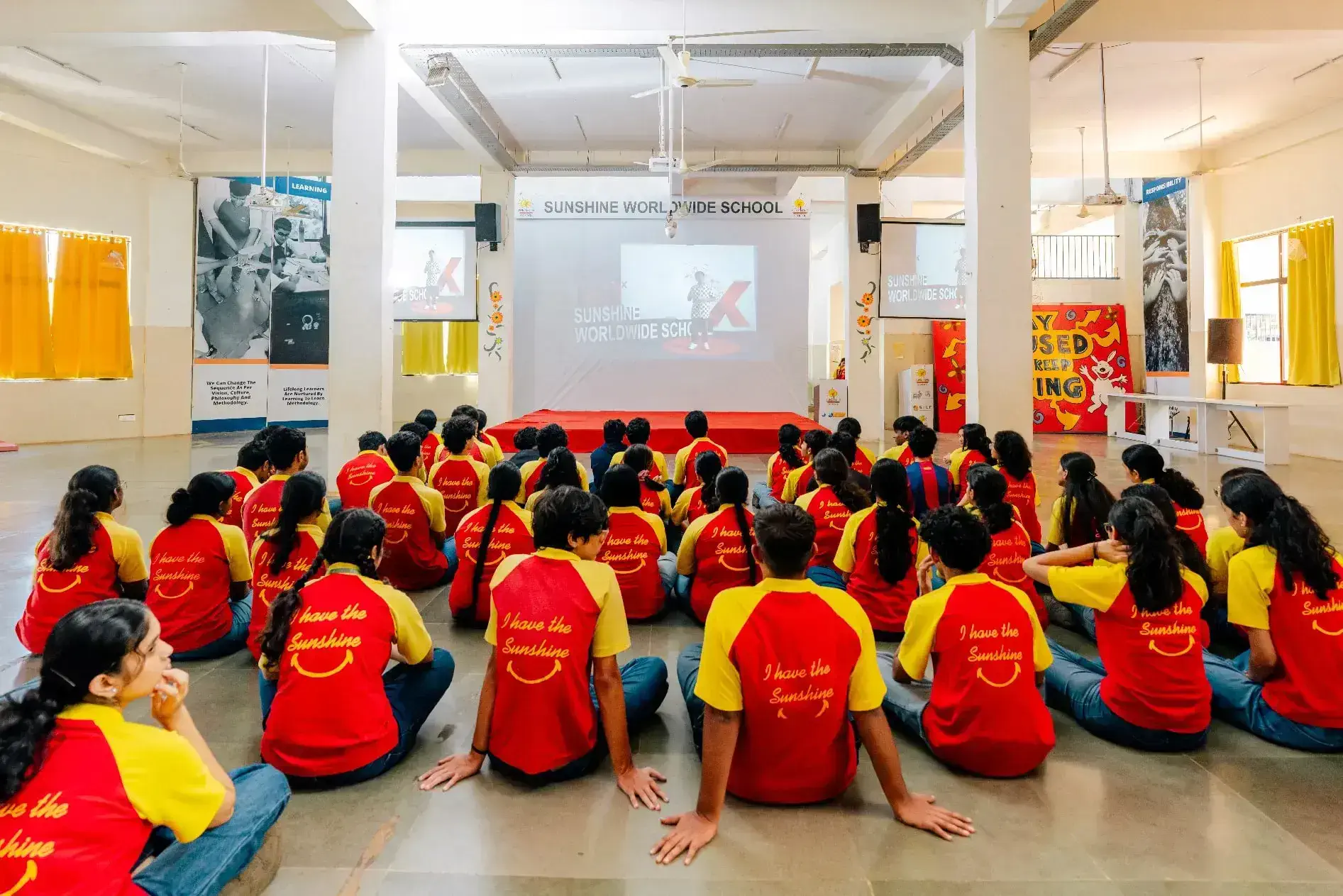 Students attentively watching screen in school hall